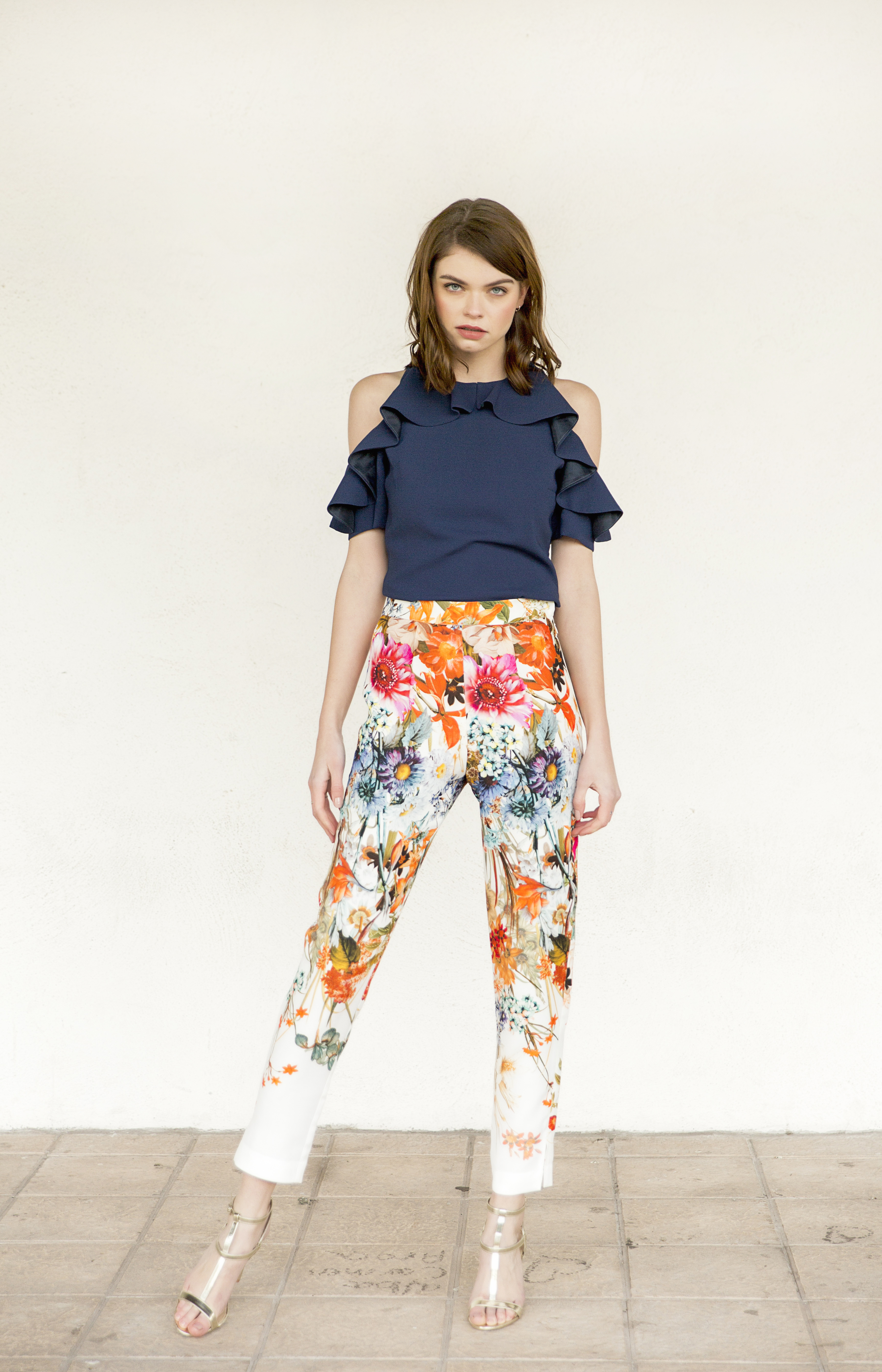 pantalon pitillo estampado con blusa azul marino y volantes